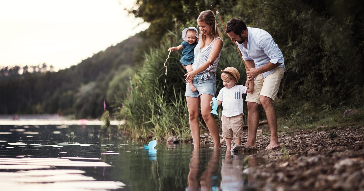 family standing at lake