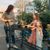 A mother and two kids put plants into a shopping cart.