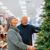 An older couple looks at a Christmas tree.