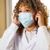 A pharmacist puts on a surgical mask.