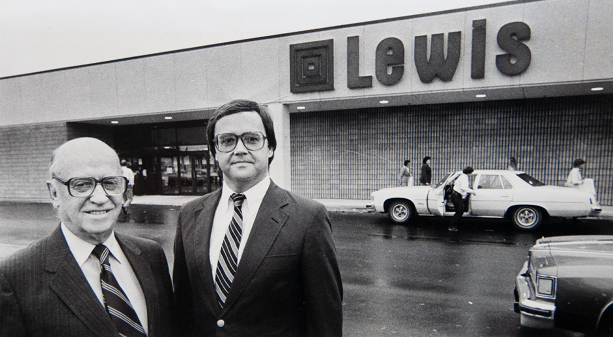 Two founders stand in front of an old Lewis store.