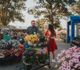 A couple pushes a cart full of plants.