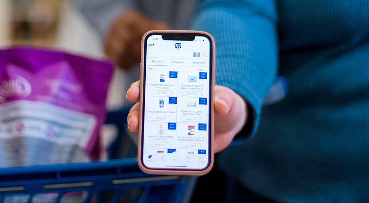 A woman holds out her phone with Lewis coupons on it.