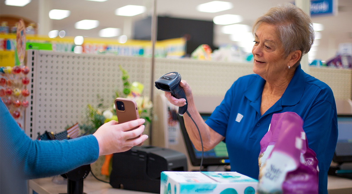 A cashiers scans a customer's phone.