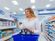 A woman grabs a box of over-the-counter medication.