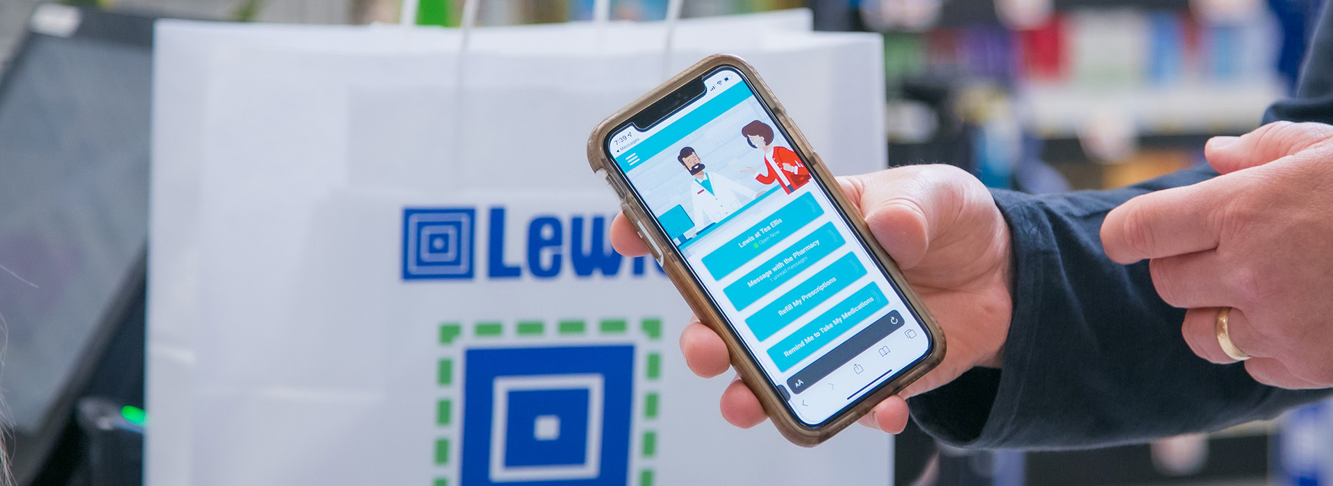 A person holds a phone with the RxLocal App on it.