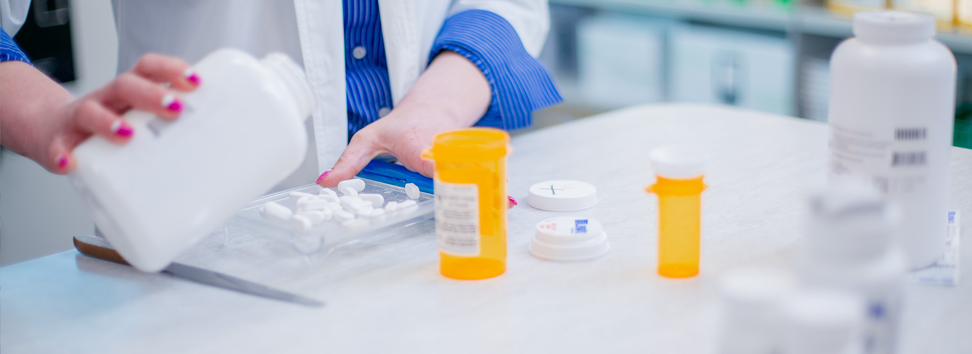 A pharmacist pours pills out of a bottle.